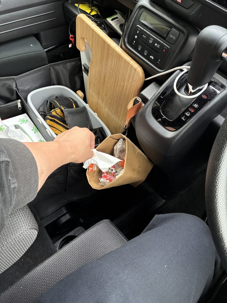 運転席からゴミ箱にゴミを捨てているところ